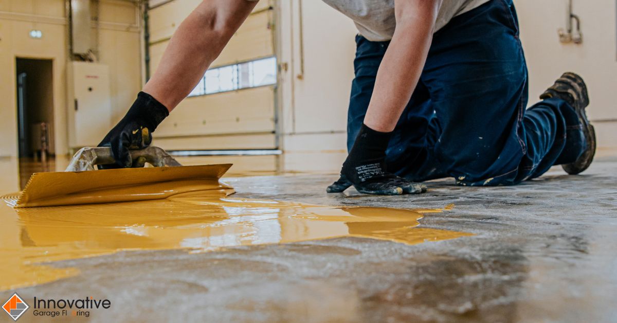 person spreading yellow liquid onto a floor - Innovative Garage Flooring polyaspartic floor coating