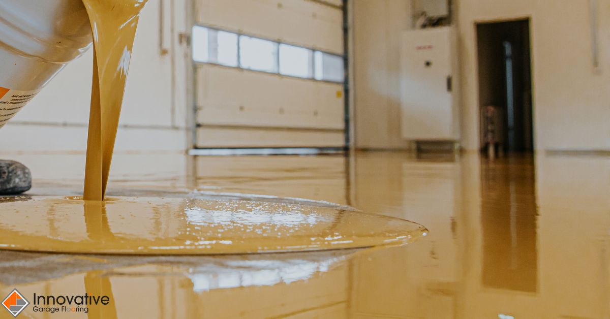 person pouring yellow liquid onto a floor - Innovative Garage Flooring polyaspartic floor coating